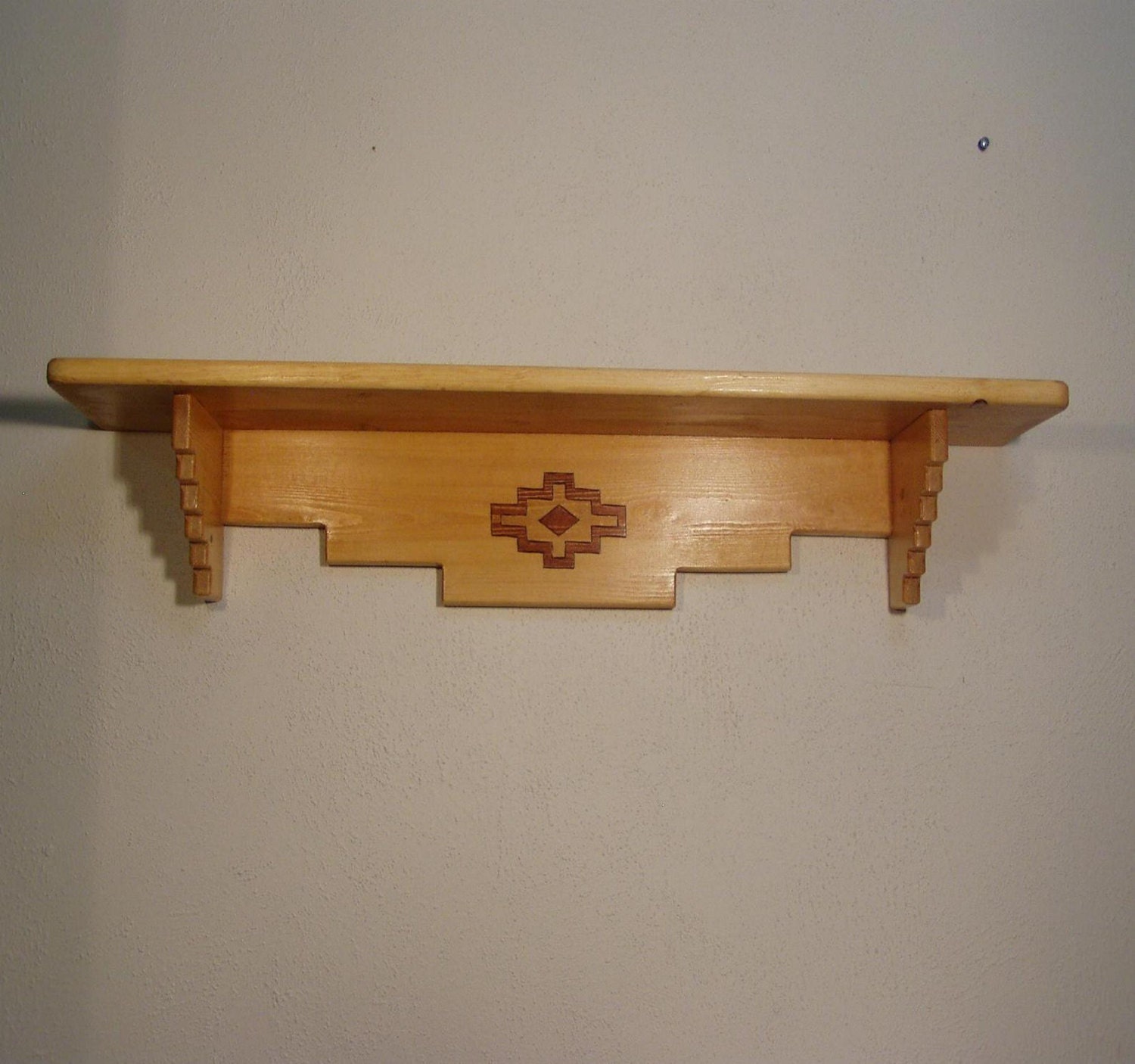 Handcrafted rustic pine wood shelf with native geometric