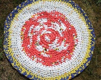 Rag rug made of upcycled cotton. Colours red-white-black-yellow-blue. Diameter abt 84 cm