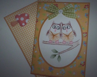 Stitched note card with matching envelope of two owls sitting on branch.