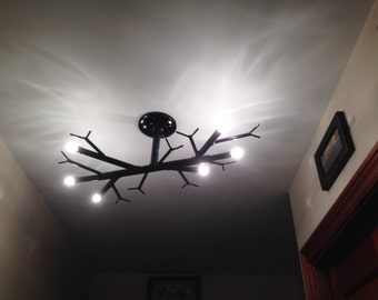 Unique hanging branch ceiling lamp, uses six 20 Watt halogen bulbs. A beautiful rustic addition to almost any space