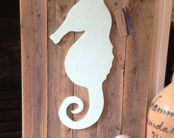 Pale turquoise seahorse on natural distressed wood panel background wall hanging