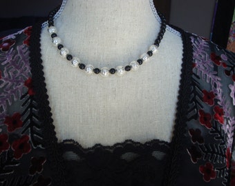 Necklace - black glass beads with silver lace look embellishments.