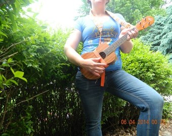 Crocheted ukulele strap-adjustable size for both height and variations of instrument. Includes a matching satchel for tuner.