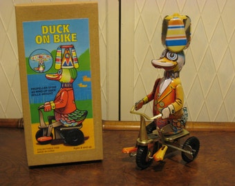 Vintage wind up tin toy duck on bike.