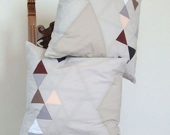 Decorative pillows with triangles graphic, for sofa, patchwork technique, gray and pastels.