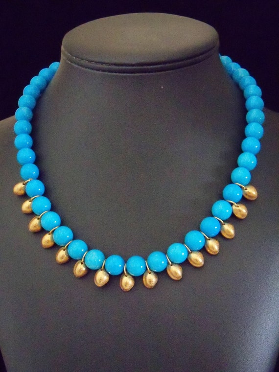 Turquoise colored dolomite with gold plated cowrie shell dangles