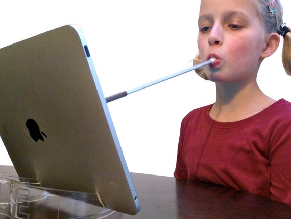 Girl using a mouth stick stylus to access and iPad