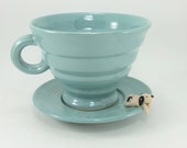 cup and saucer with a little dog