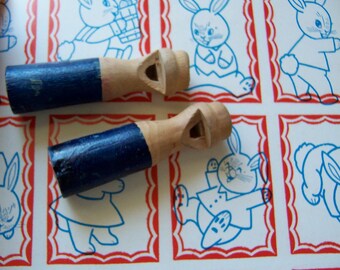 two tiny wooden whistles