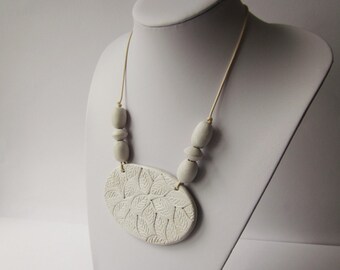 Polymer clay jewelry a pendant necklace in natural and white polymer clay.