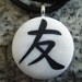 Japanese kanji symbol for FRIENDSHIP hand carved on a polymer clay white pearl color background. Pendant comes with a FREE 3mm necklace