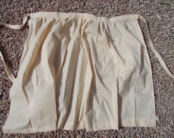 Half apron, long with 2 pockets and a tie. Length 24", Width 36-42", 9" square pockets. Solid fabrics.