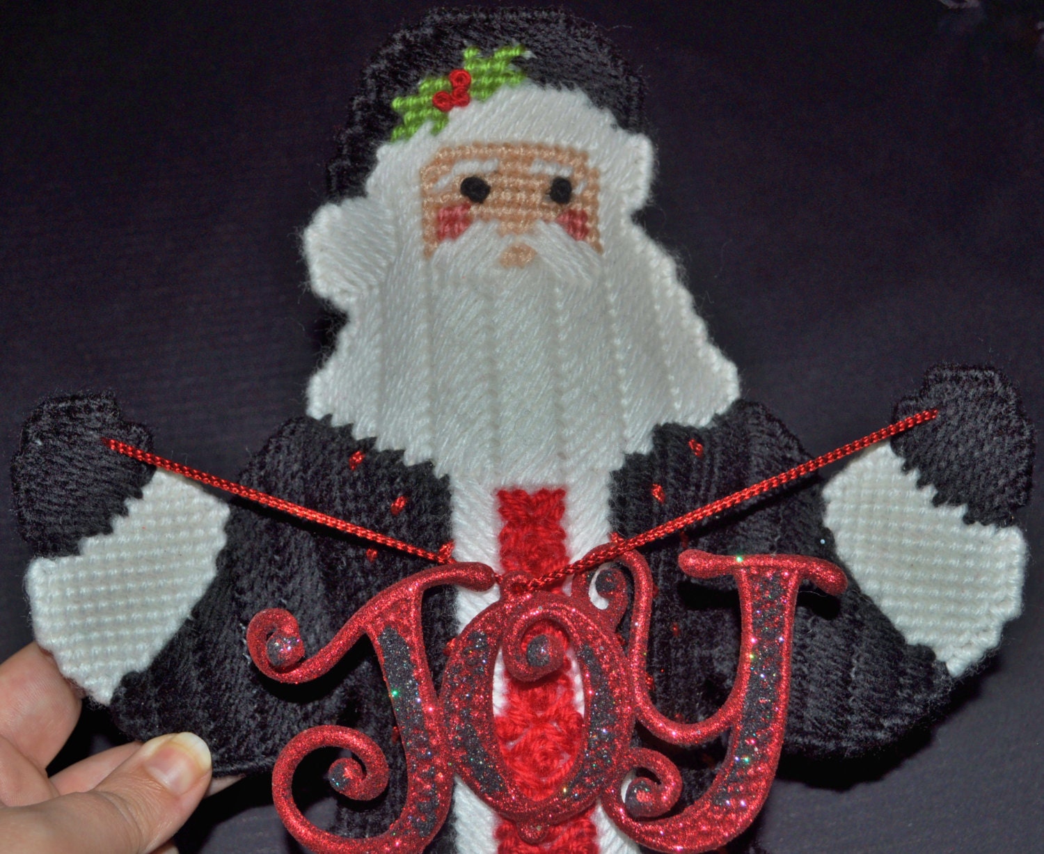 Joy to the World Santa has a Black Coat with White Trim and Red Accents