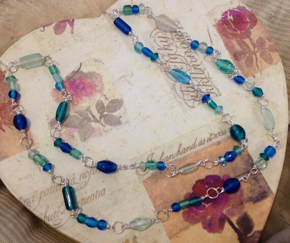 Items similar to Wire wrapped glass beads in blues on Etsy