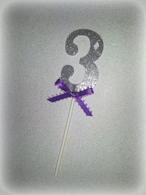 Number cake topper in silver glitter with purple bow. Number