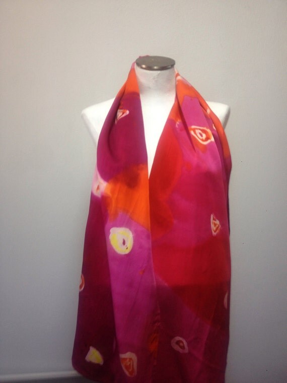 multi-color charmuese scarf. It has sections of pink, light pink and orange colors with geometric shapes