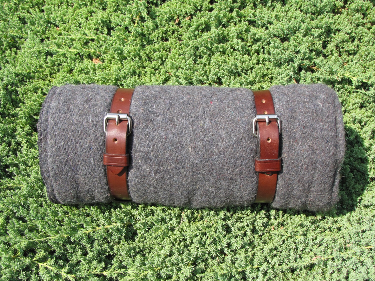 Gray Blanket Roll with brown leather straps for camping