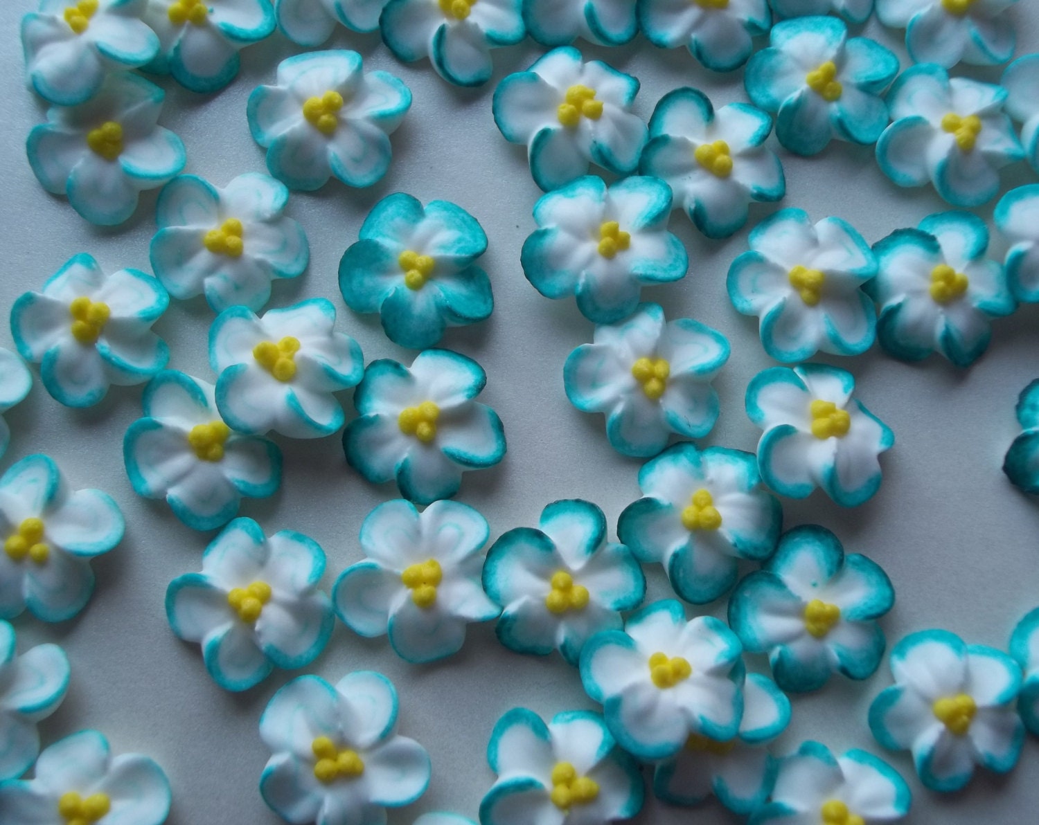 Teal-tipped white royal icing flowers by SweetSarahsBoutique