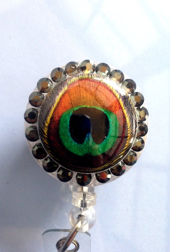 Items similar to Peacock feather retractable badge reel with Swarovski