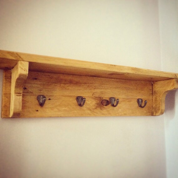 Rustic wooden coat hook rack with shelf.