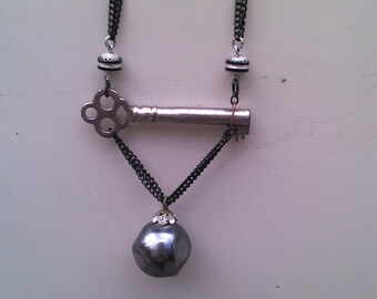 25% OFF Antique Sideways Skeleton Key Necklace: Pearly onyx pendent dangling from the key. Rhinestones around the neck of the pendent.