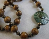 Sun face and exotic wood bead necklace on long leather cord