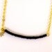 Gold chain with black beads and tiny star.