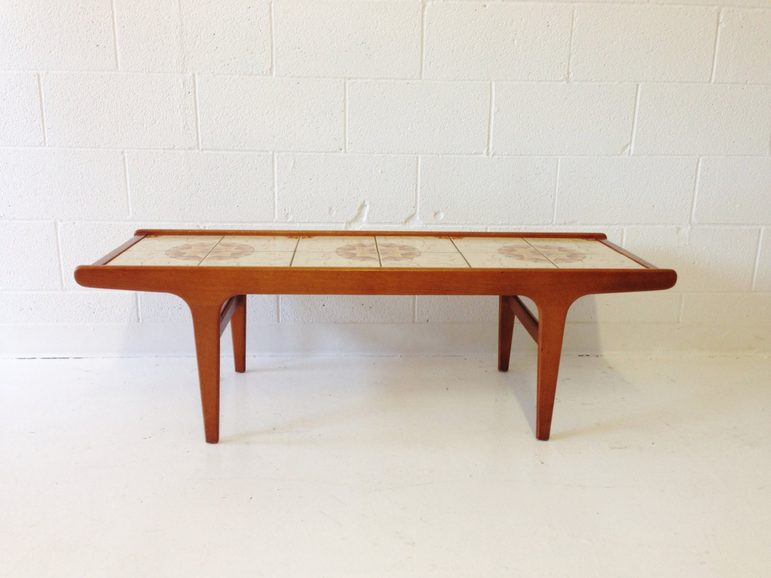 mid century modern coffee table in teak with a tile top. Haute Juice