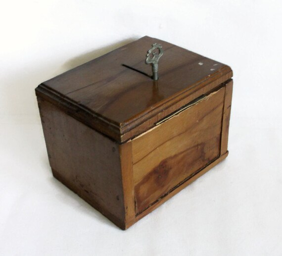 Vintage wooden tip box with ornate metal skeleton key.