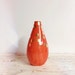 large red orange teardrop vase with gold polka dots