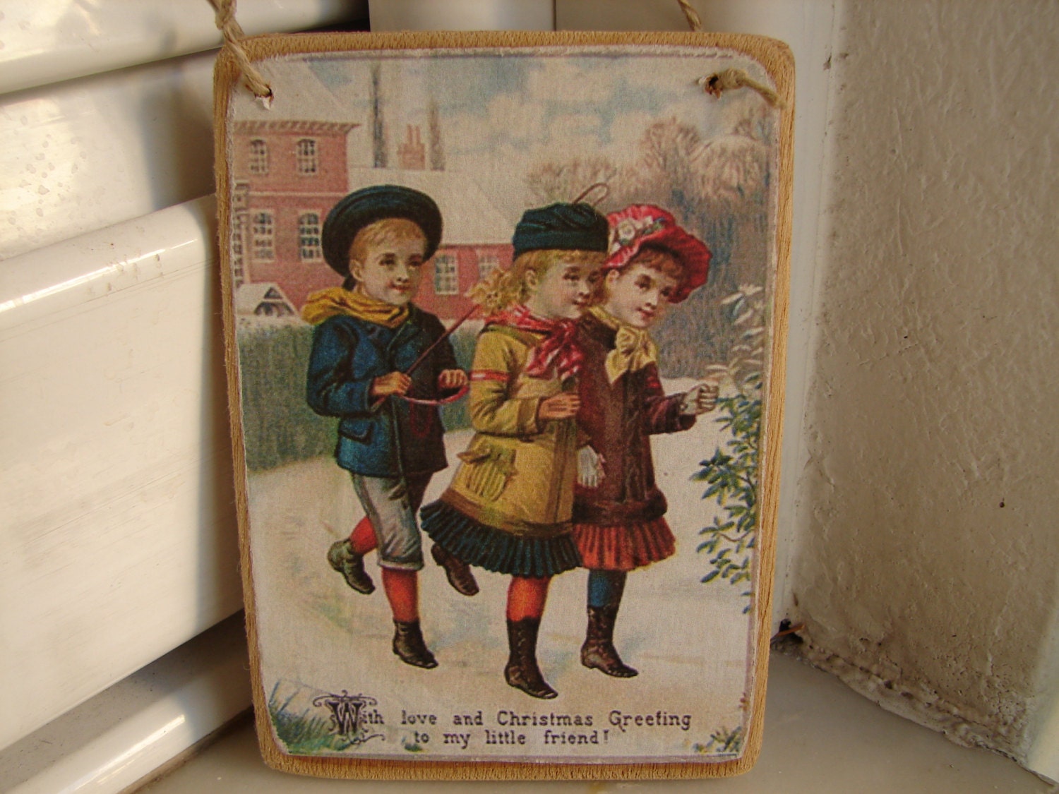 Victorian children playing in snow at Christmas image,old style tree decoration,wooden tag.