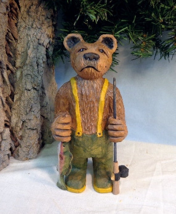 Carved fishing bear wood sculpture with fish and rod would be