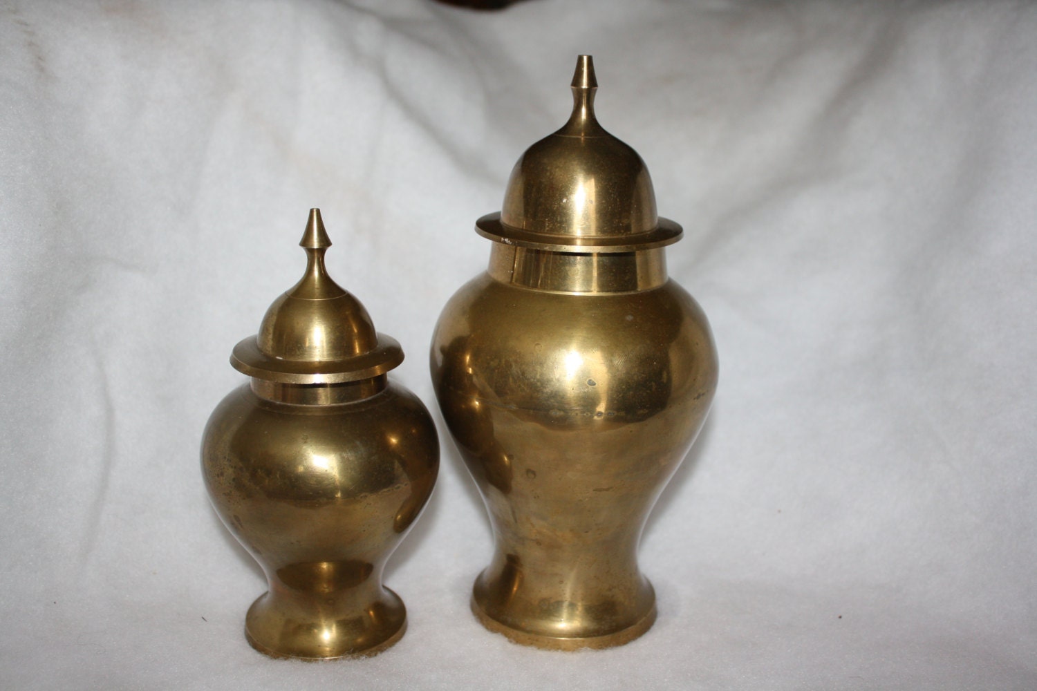 Two solid brass urns with lids