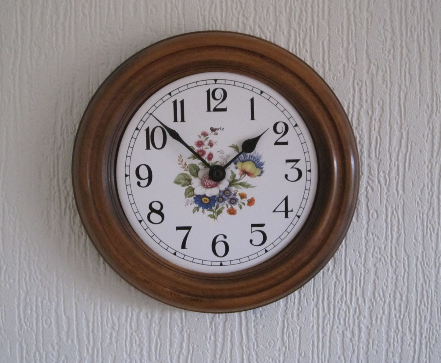 Wooden kitchen wall clock with a pretty face. Keeps accurate