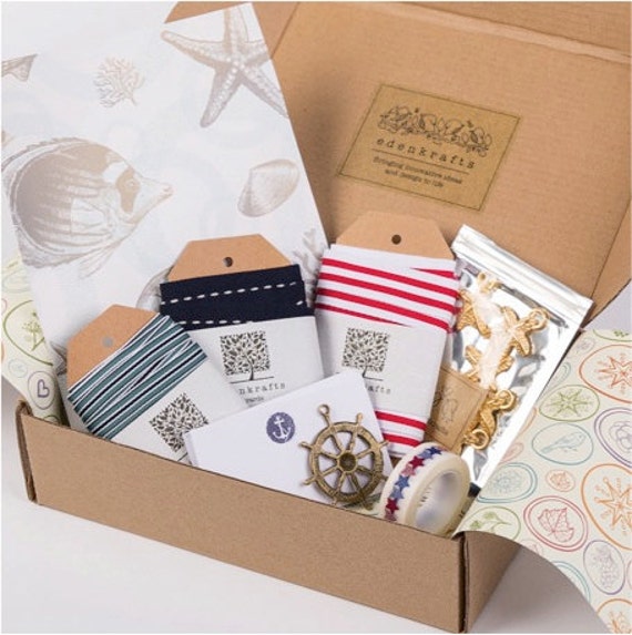 A curated + nautical themed craft box of unique, high quality craft supplies - striped ribbon, starfish embellishments, pendant, notecards