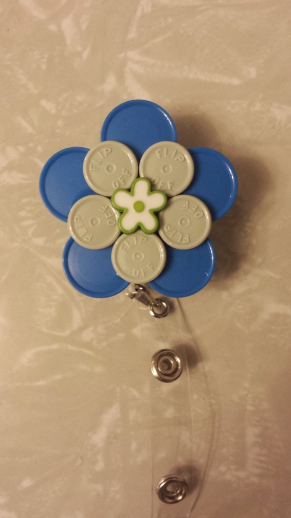 Retractable badge holder made with medicine vial caps