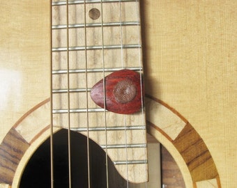 Exotic Padauk wood guitar pick with leather friction pads.