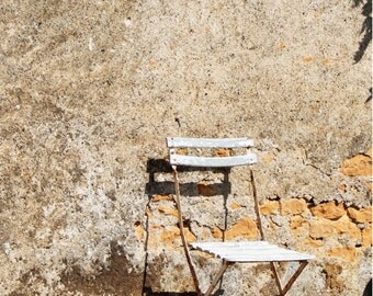 French bistro chair against an old wall (Colméry, France)