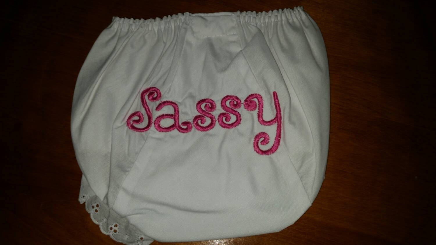 White eyelet diaper cover embroidered with Sassy in pink