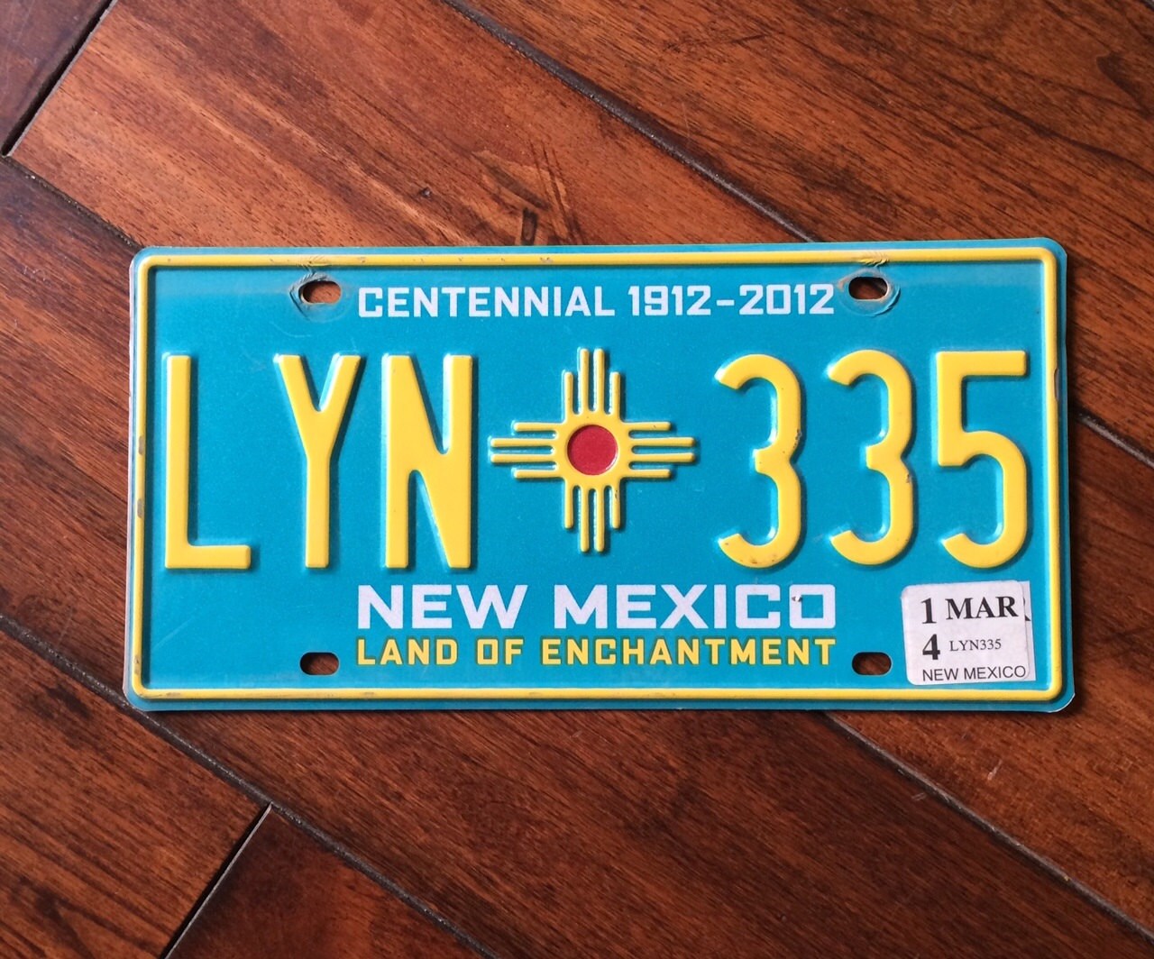 Colorful New Mexico Centennial License plate complete with