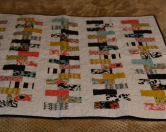 Quilted wall hanging or lap quilt. Machine pieced and quilted in beautiful corals, turquoise, black, white yellow, zipper quilt pattern
