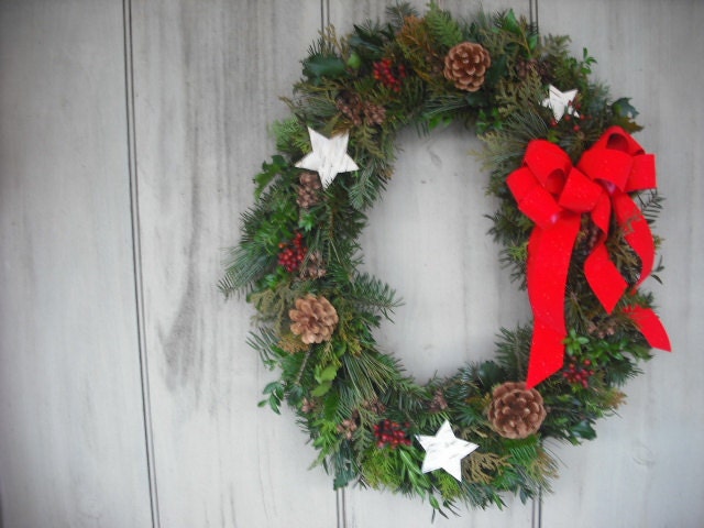 Fresh assorted evergreen Oval wreath decorated with birch bark stars, pine cones and berries.