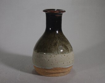 Black and white stoneware vase breaking brown at the lip.