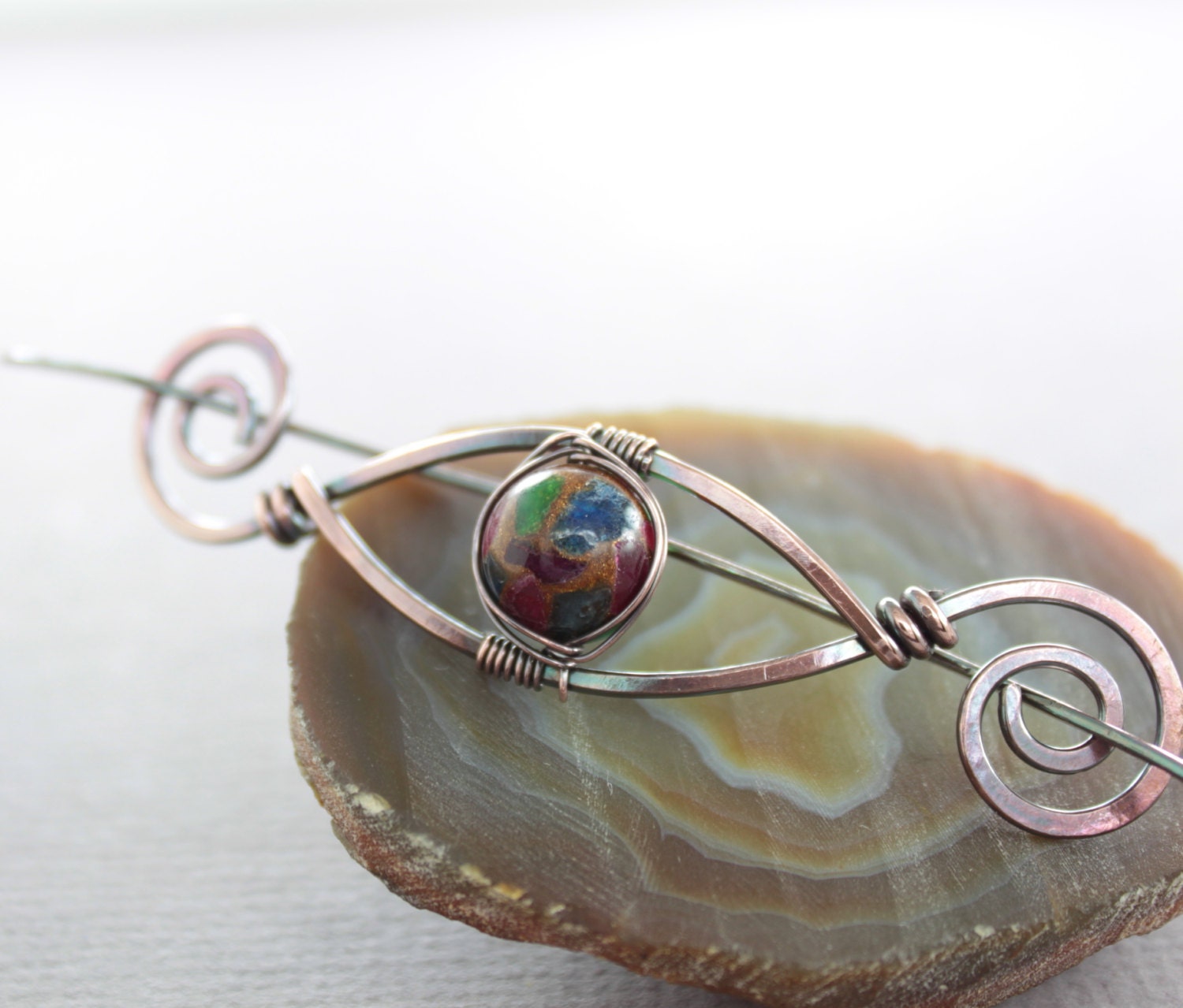 Hair barrette in a swirly eye design with copper and mosaic