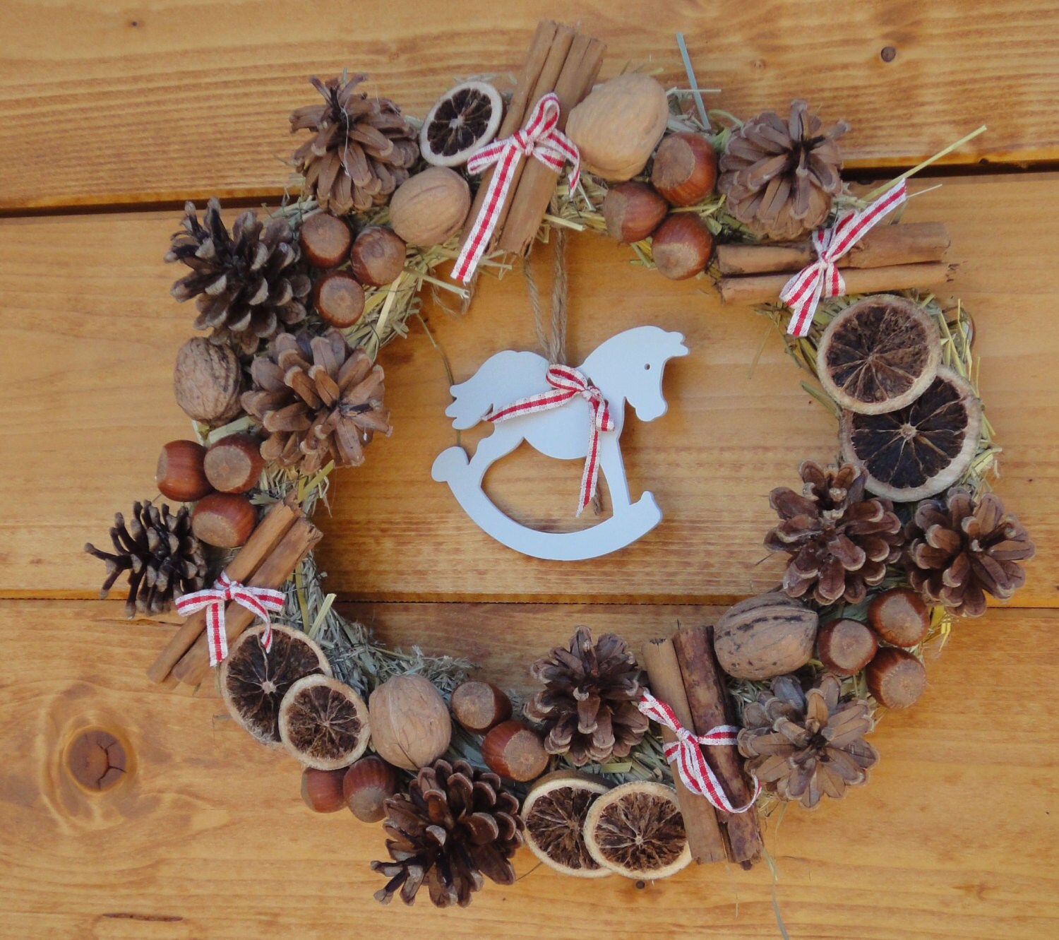 Welcome Christmas wreath with nuts, cinnamon, pine cone and rocking horse