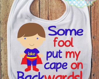 Some Fool put my cape on backwards BIB - Boy Super Hero - Baby Boy - Can choose hair color - Personalized
