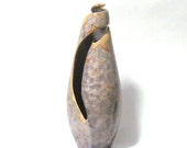 Ornamental shell ceramic form with silver crystals on light tan background