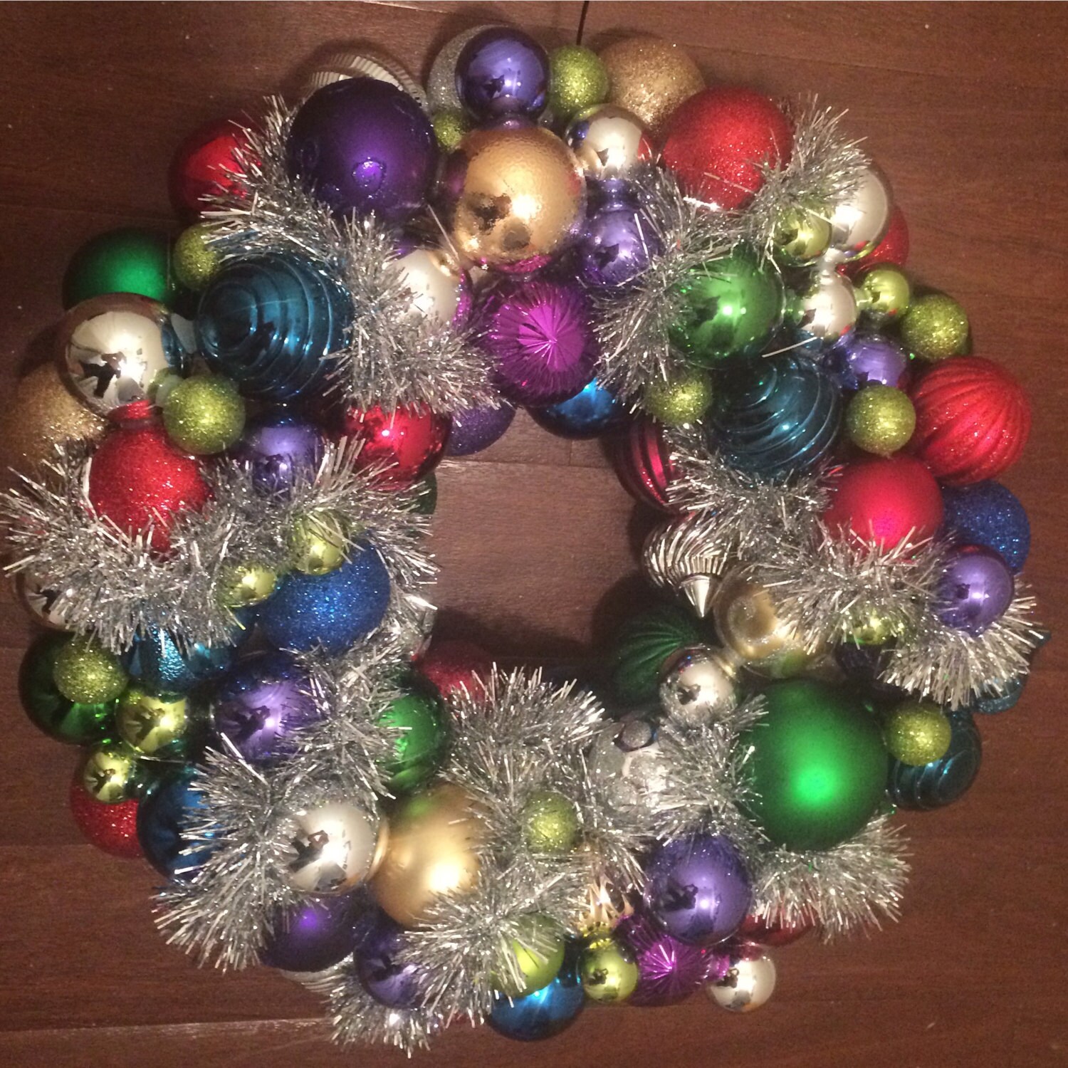 19" Handmade Christmas ornament wreath. Made from a mix of contemporary ornaments and finished with silver tinsel.