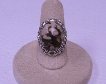 This ring has a peanut jasper stone size 7 . It has a split band .