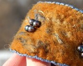 Bracelet: golden brown and blue nuno felted silk and merino wool beaded cuff wrist warmer with adjustable brass clasp. Boho style, casual